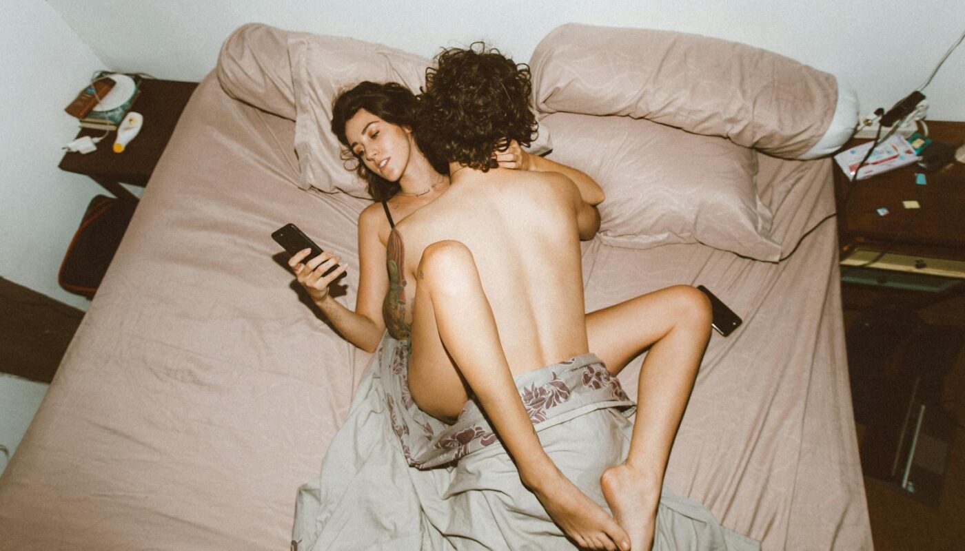 Couple having sex and using smartphone